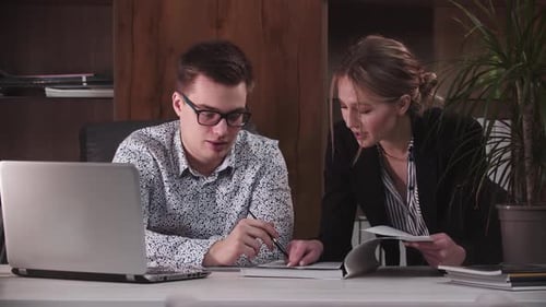 Professionals Collaborating on Documents in Office Setting