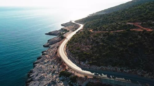 Rocky Coastline and Coastal Road Near the Sea with Driving Cars