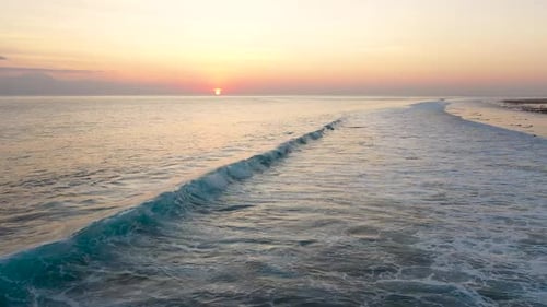 Aerial view of Gili Trawangan Island coastline, Indonesia with sunset sunlight. Big waves on sand b