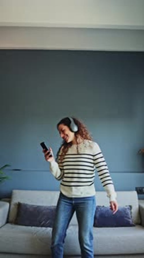 Woman Dancing at Home with Headphones and Phone