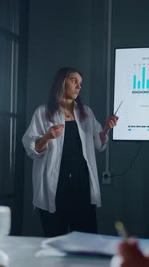 Woman Presents Data at Business Meeting in Office