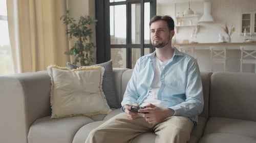 Focused Man Playing Video Games on Couch