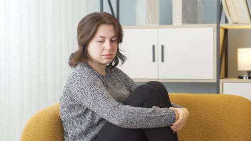 Sad Woman Sitting Indoors on Couch