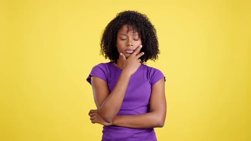 Pensive Woman Contemplates Against Yellow Background
