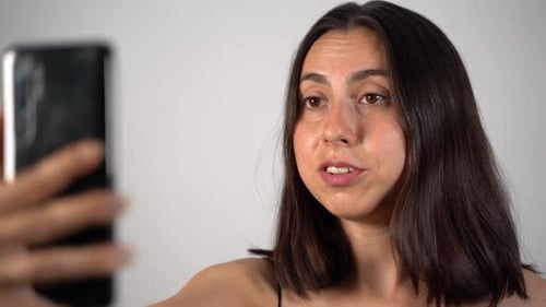 Mujer joven haciendo una llamada en línea por teléfono de cerca 4K