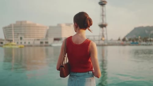 Close-up, girl stands on the seashore and looks at the bay