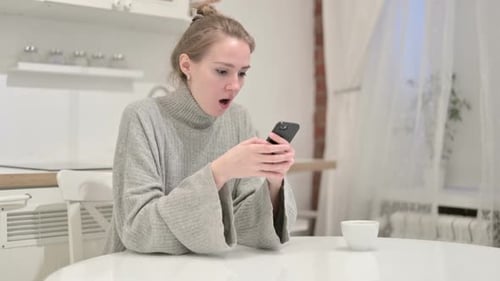 Sad Woman Looking at Smartphone Indoors