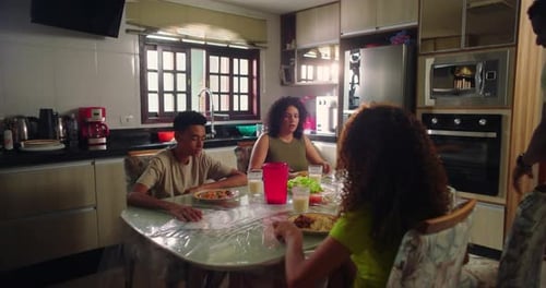 Family Holding Hands Before Eating Dinner at Home
