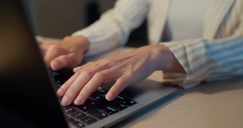 Hands Typing on Laptop Keyboard in Office