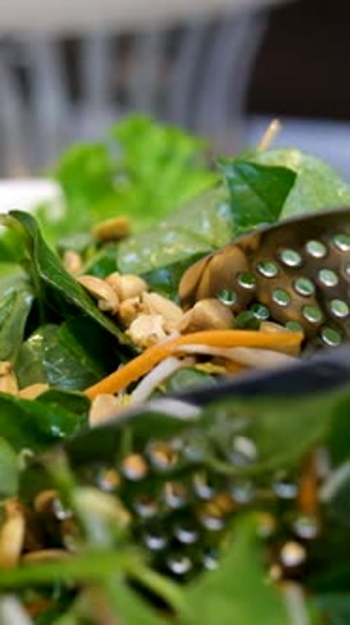 Tossing Fresh Green Salad Close Up Vertical Format