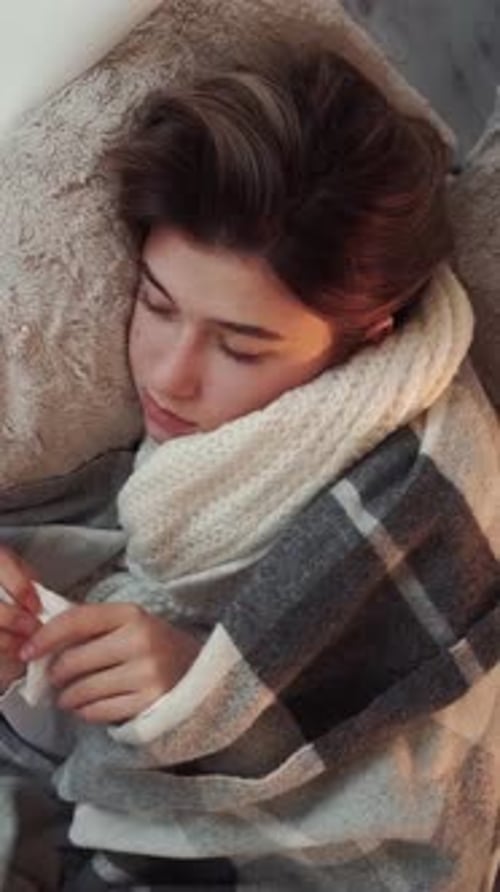 Woman Wrapped in Scarf Lies in Bed