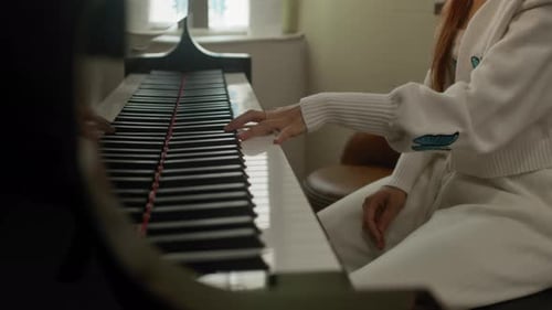 Close up on woman playing piano one hand. Piano lessons. Slow motion.