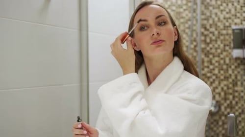 Woman Applying Makeup in the Bathroom