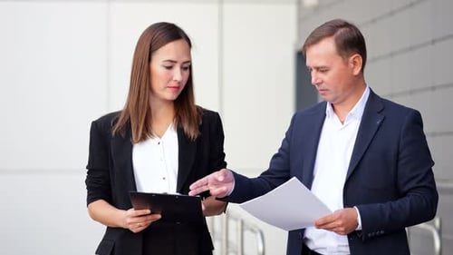 Focused Business Team Reviewing Documents Outside Office
