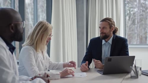 Male Investor and Two Doctors Discussing Clinic Issues