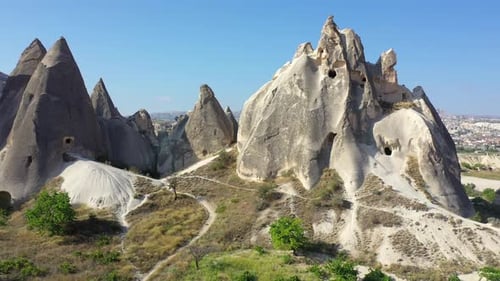 Rock cut caves in fairy chimneys in Cappadocia landscape, backwards aerial