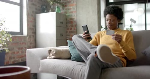 Young Adult Online Shopping on Sofa with Phone