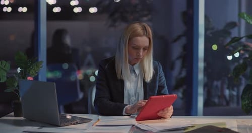 Jolie jeune femme blonde utilisant une application de bloc-notes pour tablette et naviguant sur Internet en recherchant des actualités