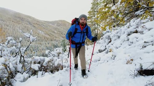 Hiker Walking in Winter Snowy Forest Tourist Man with Big Backpack Walking Along the Road in