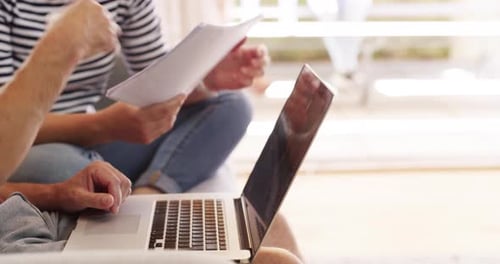 Adults working together using laptop and papers