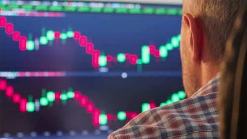 Trader Works Behind Computer Screens Filled with Charts and Data Analysis