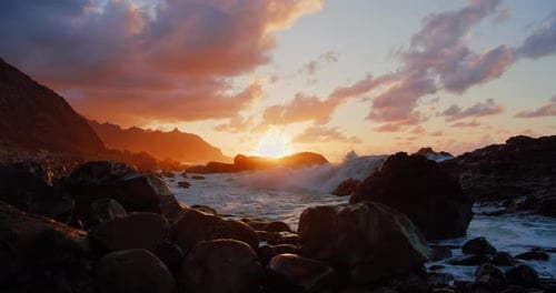 Atlantic Ocean sunset. Scenic ocean rocky volcanic beach. Sea waves splashing on stones. North of Te