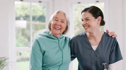Smiling Caregiver With Senior Woman At Home