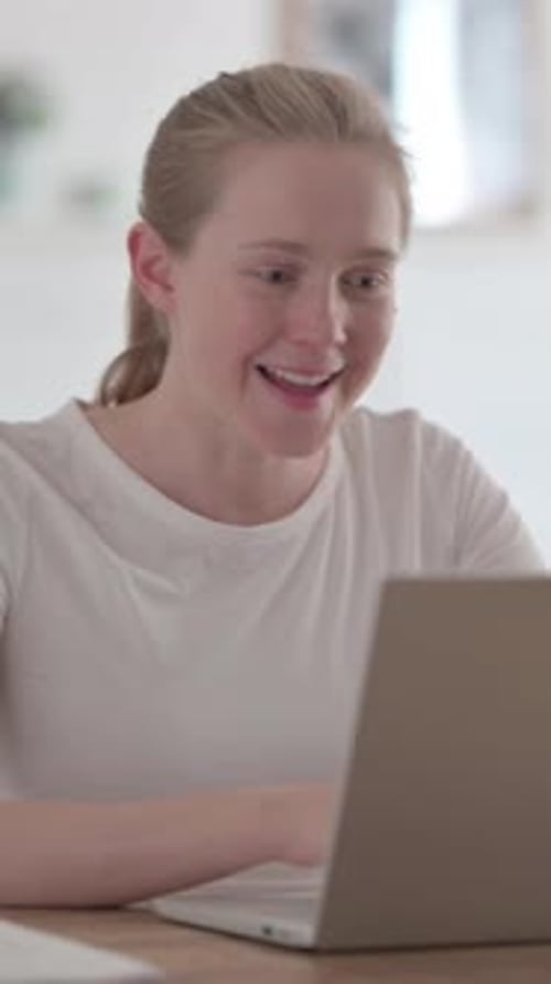 Beautiful Young Woman Celebrating Success while using Laptop in Office, Vertical Video