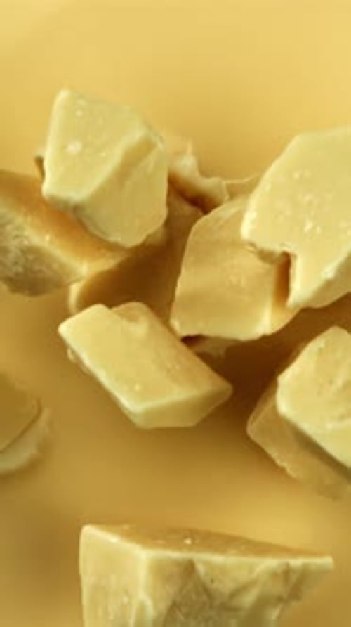 Super Slow Motion Pieces of White Chocolate Fall Into Liquid Chocolate Filmed on a Highspeed Camera