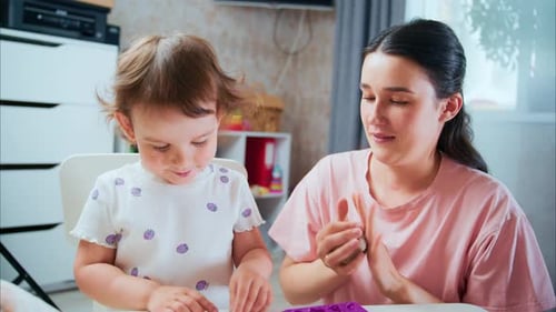 Cheerful Mother and Child Play with Clay Indoors