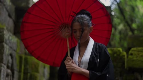 Woman Wearing A Kimono And Holding A Wagasa Looks At Camera