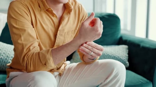 Man, hands or wrist pain in home with massage, carpal tunnel or poor blood circulation on sofa