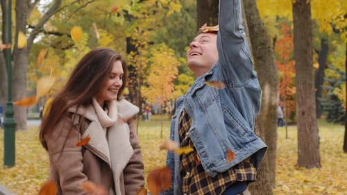 Romantic Couple Throwing Leaves in Autumn Park