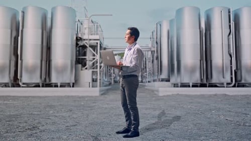 Asia Male Use Laptop And Looking Around at Chemical Plant