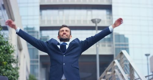 Successful Young Adult Man Cheering in Front of Office