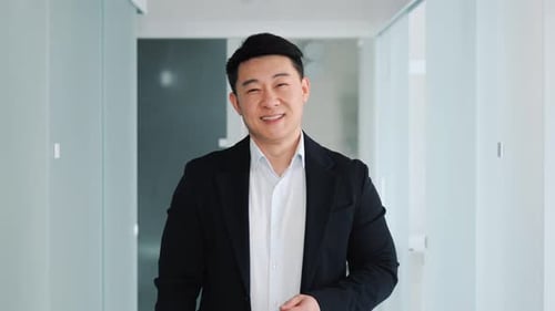 Smiling Business Man Standing in an Office Hallway
