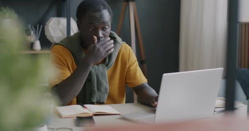 Man Working on Laptop at Desk in Home