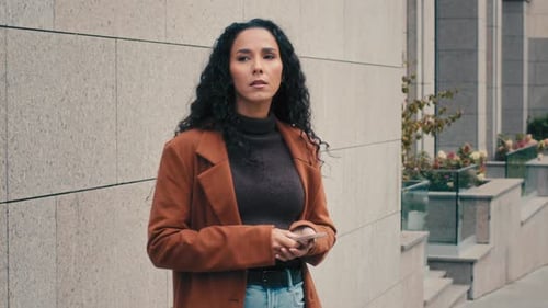 Woman Using Phone in Urban Environment
