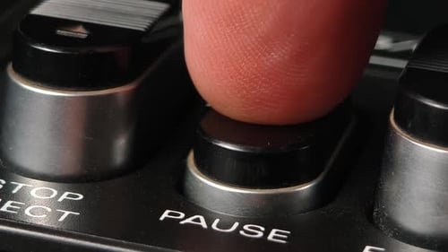 Finger drückt auf dem alten Player die Pause-Taste