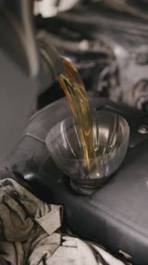 Pouring Golden Oil into Car Engine Close Up