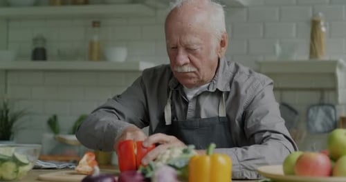 Senior Man Prepares Vegetables in Bright Kitchen