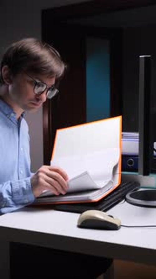 Vertical Video Accountant Working Late at Night in Office Reading Documents