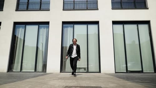 Confident Step and Gait of a Stylish Man in a Black Leather Jacket