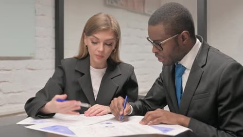 Multi Ethnic Business People Working on Documents in Office