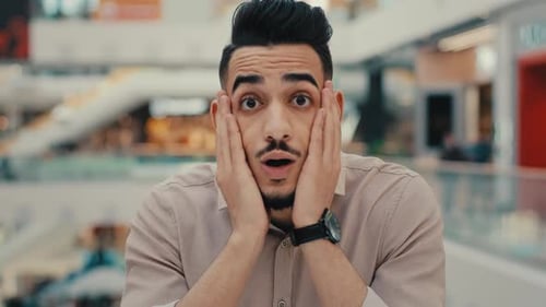 Man Expressing Surprise and Happiness in Shopping Mall