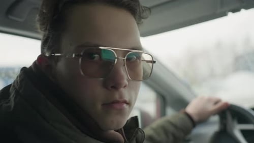 Young Adult Driving Car on Cloudy Day