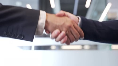 Close up of business handshake symbolizing teamwork and cooperation. Two male professionals shaking