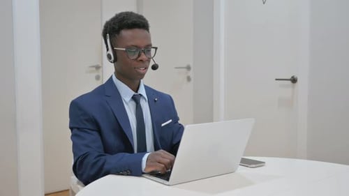 African Businessman on a Video Call with Earbuds in Call Center