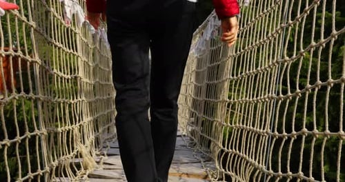 Older women with backpack passing Himalayan sidewalk path Skywalk wooden construction with colored f