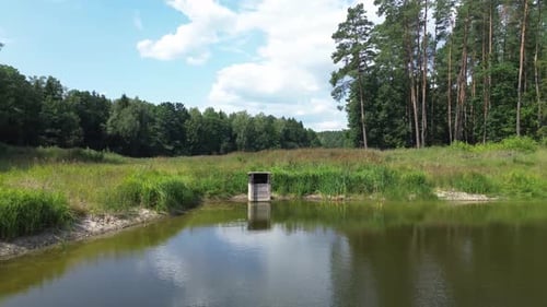 „Die Drohne gleitet über Europas See im Morgenlicht und fängt eine ruhige Lagune, üppige Wälder und natürliche Teiche ein
